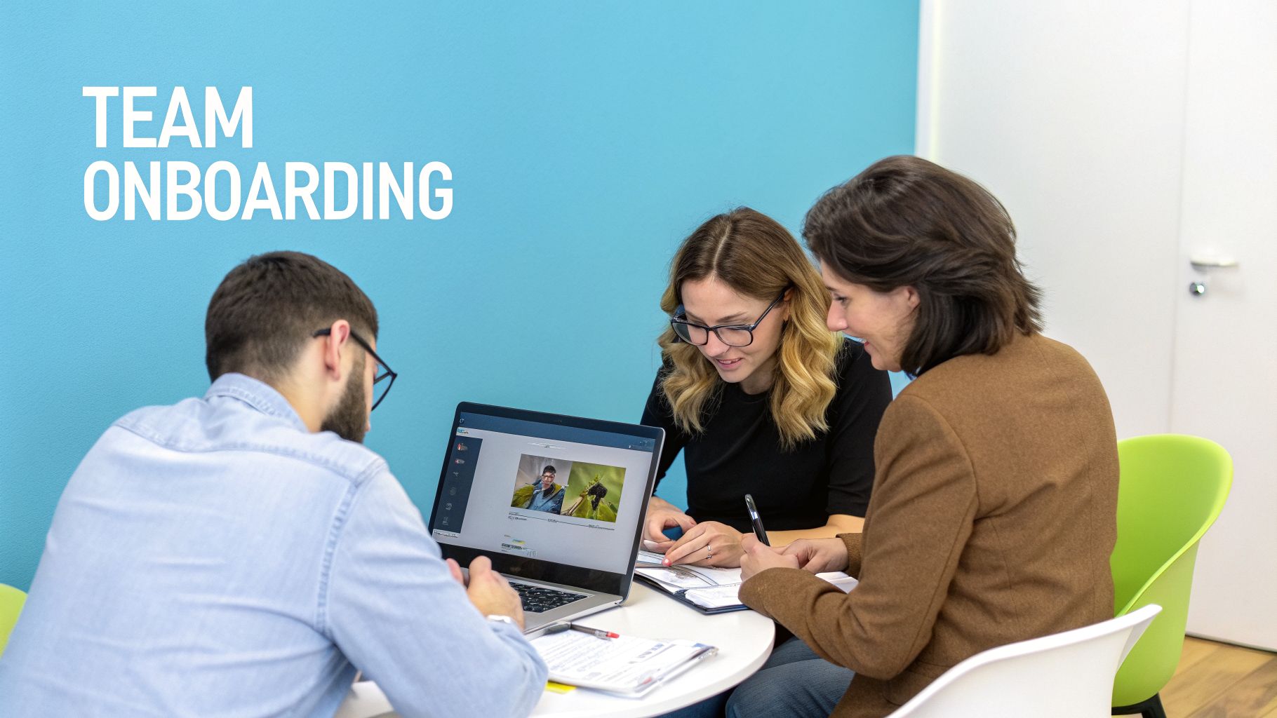 Three colleagues discuss a presentation on a laptop during a team onboarding session.