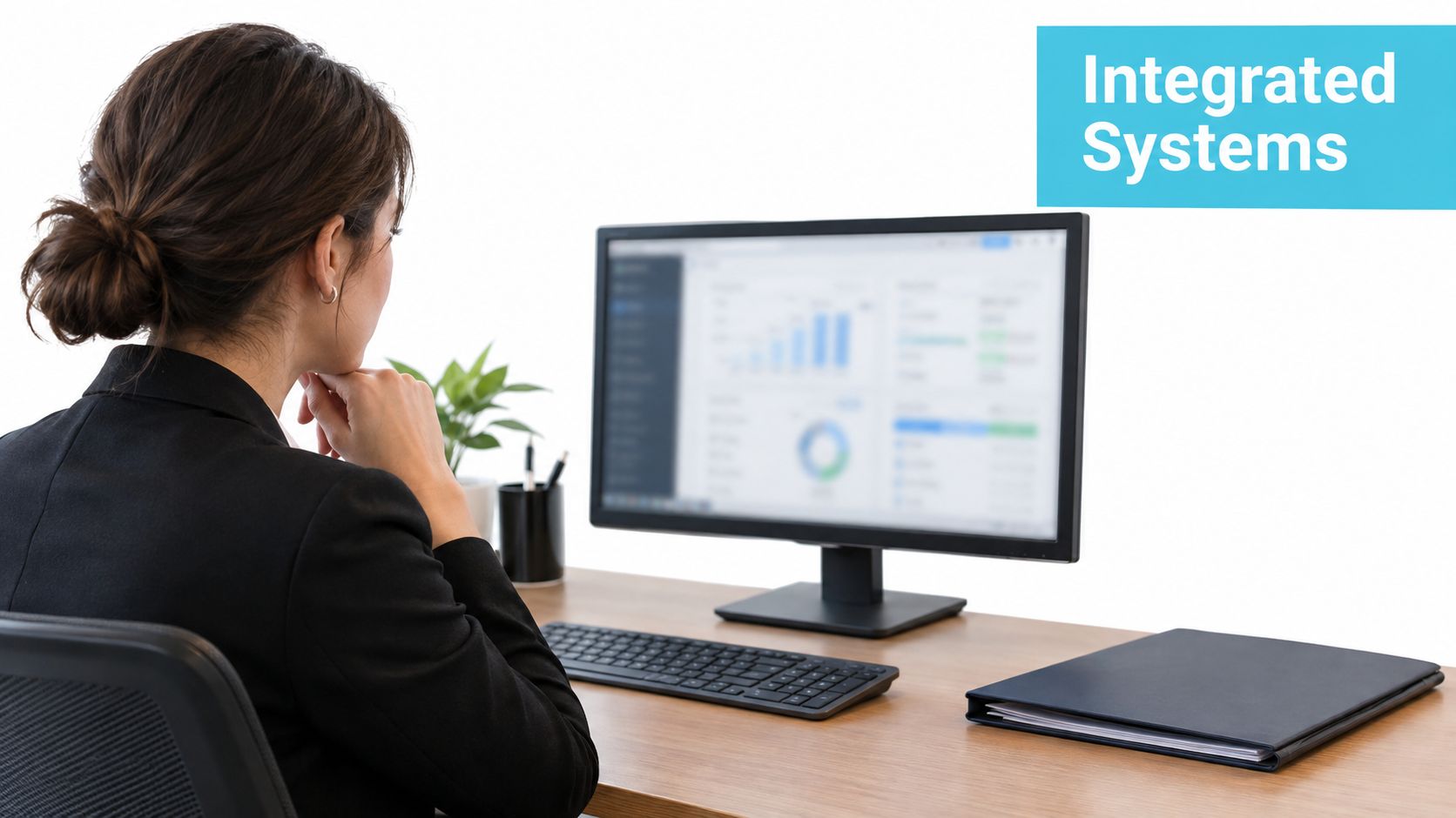 A professional woman in a business suit reviewing analytics and data on her computer monitor.